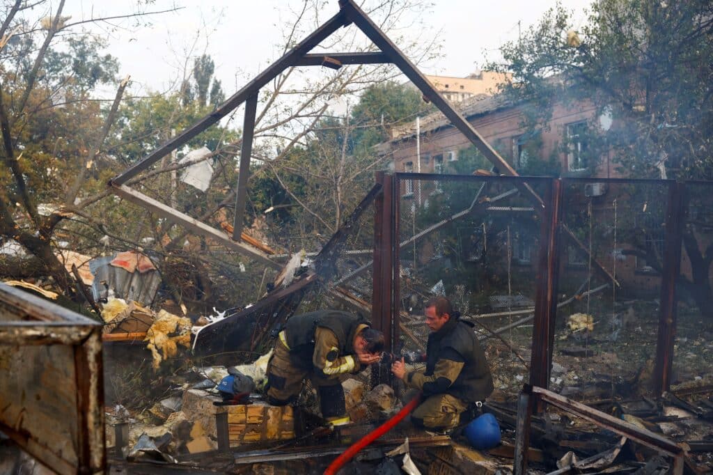 Hasiči v rezidenční čtvrti, která byla poškozena během ruského raketového útoku, Kyjev